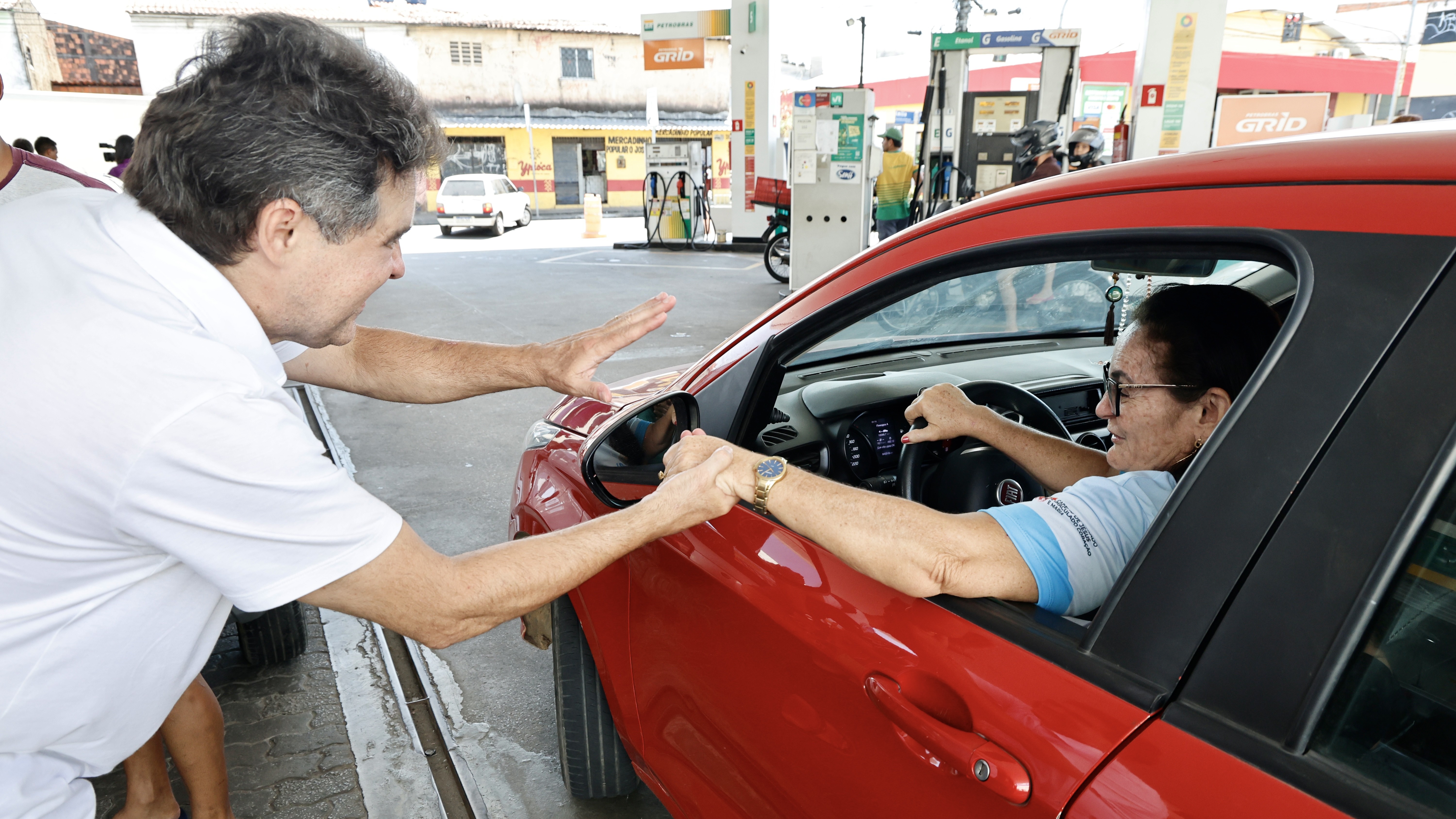 Prefeito Evandro cumprimenta uma mulher dentro do carro